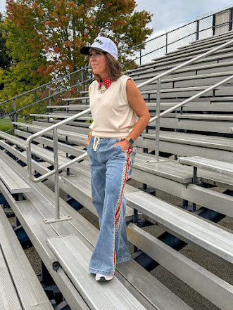 Light wash denim-like wide leg pants with leo and red striping down the sides and elastic, drawstring waist.