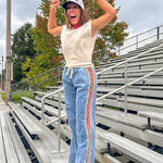 Light wash denim-like wide leg pants with leo and red striping down the sides and elastic, drawstring waist.