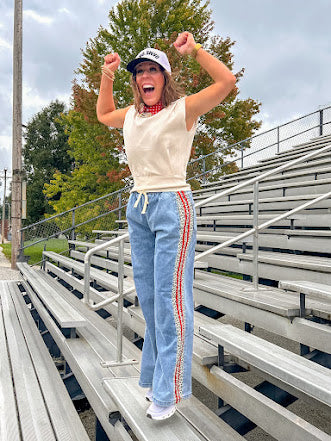 Light wash denim-like wide leg pants with leo and red striping down the sides and elastic, drawstring waist.