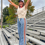 Light wash denim-like wide leg pants with leo and red striping down the sides and elastic, drawstring waist.