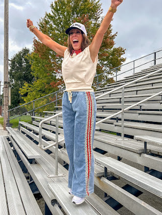 Light wash denim-like wide leg pants with leo and red striping down the sides and elastic, drawstring waist.
