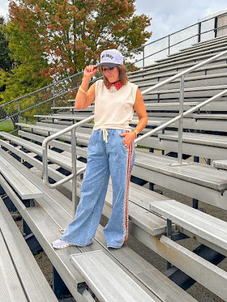Light wash denim-like wide leg pants with leo and red striping down the sides and elastic, drawstring waist.