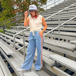 Light wash denim-like wide leg pants with leo and red striping down the sides and elastic, drawstring waist.