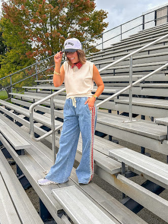 Light wash denim-like wide leg pants with leo and red striping down the sides and elastic, drawstring waist.