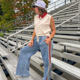 Light wash denim-like wide leg pants with leo and red striping down the sides and elastic, drawstring waist.