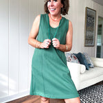 Terry-like forest green sleeveless hoodie dress with drawstring. Mini length.